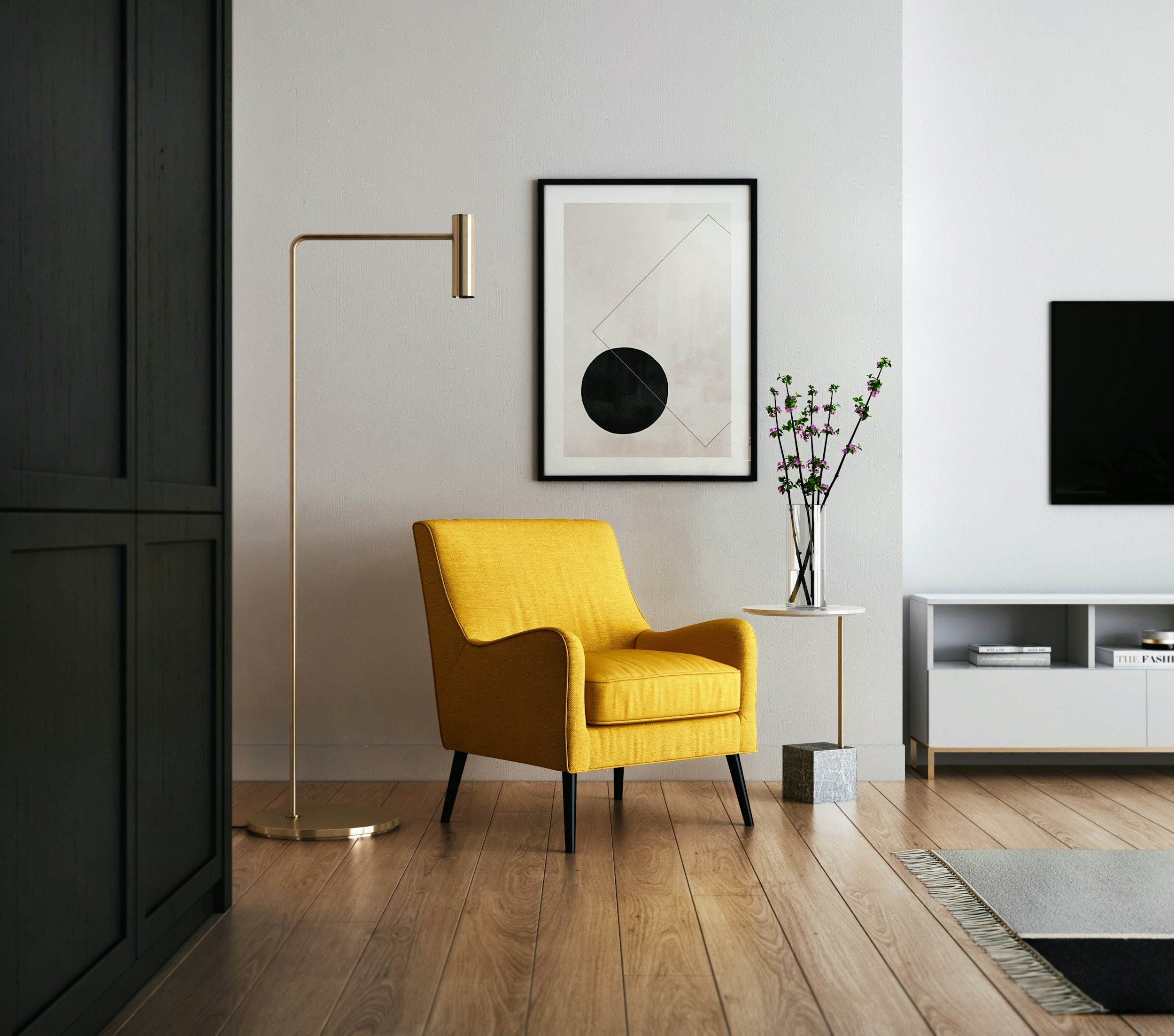 Modern interior with a yellow armchair, framed abstract art, floor lamp and flowers in a glass vase.